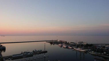 Gdynia limanının sabah erken saatlerinde limandaki gemiler altyapı limanı ve yumuşak gün ışığı altında sakin Baltık Denizi manzarası.