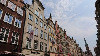 Gdansk, Polonya, Haziran 07 2019. Gündüz vakti dükkanları ve kafeleri olan eski kasaba caddesi boyunca uzanan renkli tarihi konak evleri..