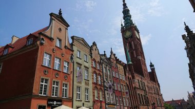 Gdansk, Polonya. Haziran 07, 2019. Eski kasaba caddesi boyunca uzanan renkli tarihi konak evleri ve arka planda ana belediye binası görünüyor..