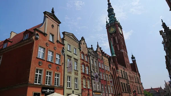 Gdansk, Polonya. Haziran 07, 2019. Eski kasaba caddesi boyunca uzanan renkli tarihi konak evleri ve arka planda ana belediye binası görünüyor..