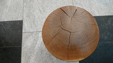 Geometrik taş zemine yerleştirilmiş kırık tahta bir kütüğün üst görüntüsü tasarım arka planı ve minimum bileşim için uygun doğal soyut bir doku oluşturuyor..