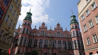 Gdansk, Polonya. Haziran 07, 2019. Dlugi Targ caddesi boyunca mavi bir gökyüzünün altında tarihi konutlar tarafından çerçevelenmiş Süslü Yeşil Kapı.
