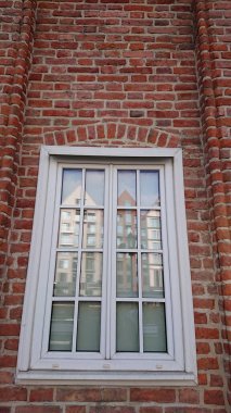 Gdansk, Polonya. Haziran 07, 2019. Eski Gdansk kasabasındaki modern binaları yansıtan beyaz çerçeveli tarihi kırmızı tuğla cephe.