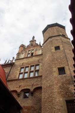 Gdansk, Polonya. Haziran 07, 2019. Tarihsel tuğla kule ve ortaçağ mimari detayları bulutlu gökyüzünün altında alçak bir açıdan görülebilen güçlendirilmiş bir binanın..