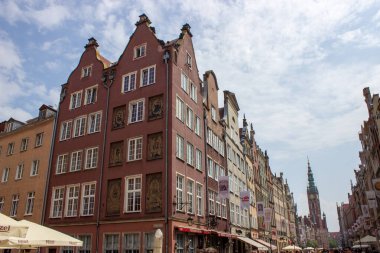 Gdansk, Polonya. Haziran 07, 2019. Dluga Caddesi 'ni kaplayan tarihi renkli konak evleri ve arka planda belediye kulesi var..