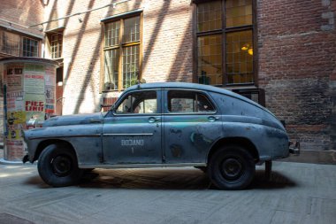 Gdansk, Polonya. Haziran 07, 2019. Tuğla mimarisi ve geleneksel pencerelerle çevrili tarihi bir kasaba avlusunda park edilmiş klasik bir taksi arabasının yan görüntüsü..