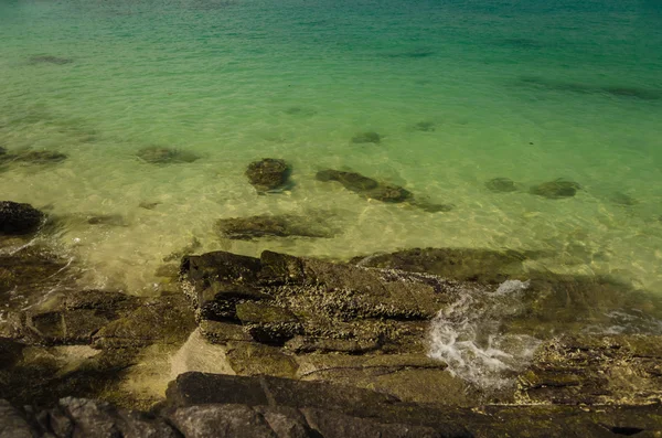 Stenarna på stranden och havet vatten. — Stockfoto