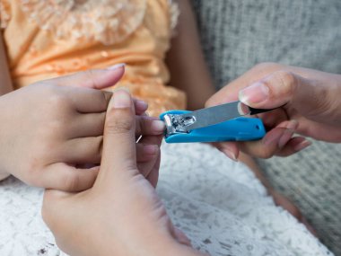 Tırnak makasıyla tırnaklarını kesen bir kadının yakın çekimi..