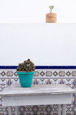 Köy ahşap bir masada turkuaz bir tencerede geleneksel fayanslara karşı sulu.