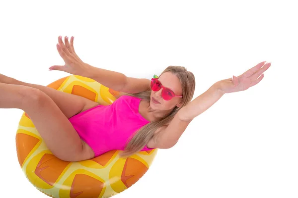 一位身穿粉色泳衣的年轻女子躺在一个充气的泳圈上 — 图库照片