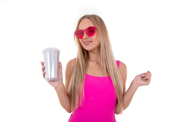 一位穿着粉色泳衣的年轻女子在白色背景下喝柠檬水 — 图库照片