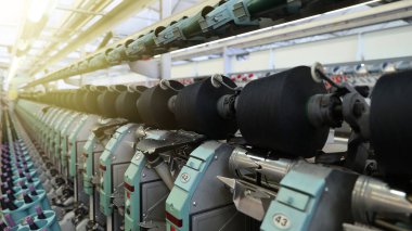 İplik üreten makinelere yakın çekim. İp ve kumaş üretimi için bir fabrika