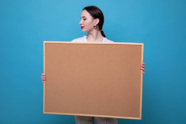 Mavi arka planda tahtası olan esmer bir kadın.