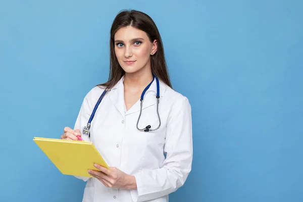 Beyaz önlüklü genç bir doktorun portresi günlükte yazıyor.