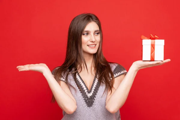 赤い背景にギフトボックスを持つ若い女性の肖像画 — ストック写真
