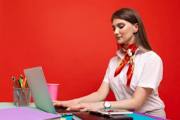Beyaz Gömlekli Genç Bir Kadın Kırmızı Arka Planda Dizüstü Bilgisayarda — Stok fotoğraf
