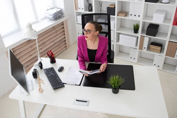 A girl in a business style works with documents in the office