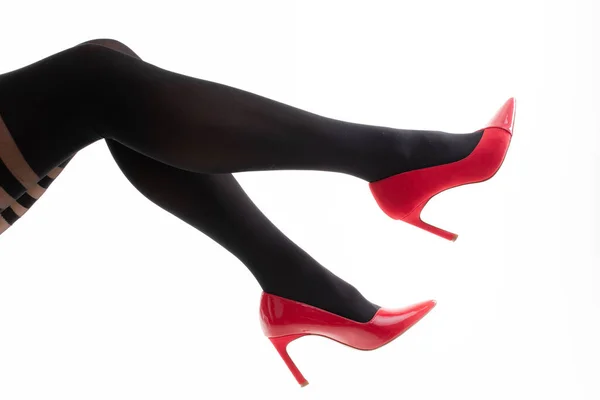 女腿穿花纹紧身裤和红色高跟鞋的特写 — 图库照片