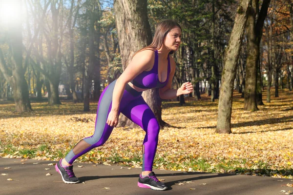 A girl in a tracksuit runs around the park. Exercise in the fresh air