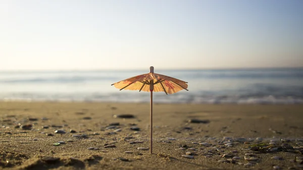 En liten cocktail paraply på stranden — Stockfoto
