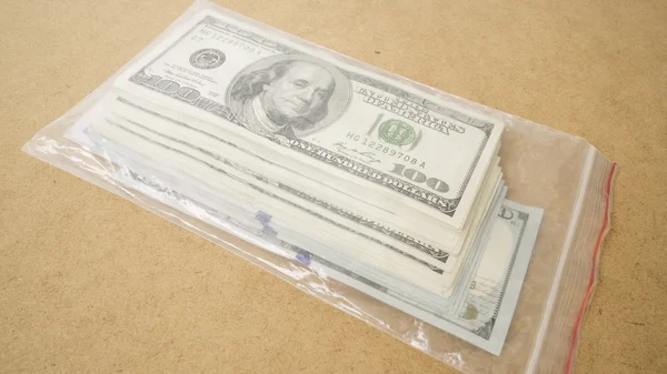 Lots of dollar bills packed in a plastic bag — Stock Photo, Image