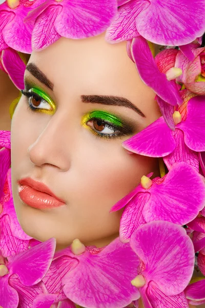 Chica con orquídeas rosadas en la cara — Foto de Stock