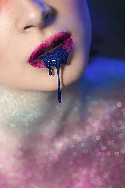 Maquillaje de fantasía en sus labios azul. Esmalte de uñas azul fluye de los labios de un modelo — Foto de Stock