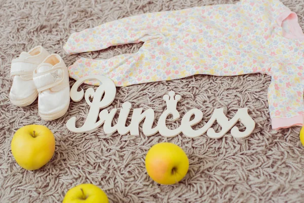 Kleidung und Schuhe für Babys und Äpfel. Wohnkultur Teller Prinzessin — Stockfoto