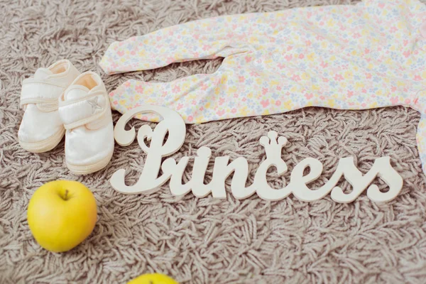 Oděvy a obuv pro miminka a jablka. Domů dekor desky princezna — Stock fotografie