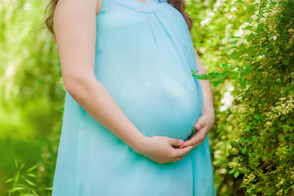 春の花の咲く庭で若い妊婦 — ストック写真