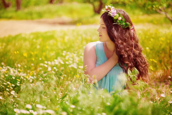 Mujer embarazada joven en el campo de primavera de las margaritas en flor y dientes de león — Foto de Stock