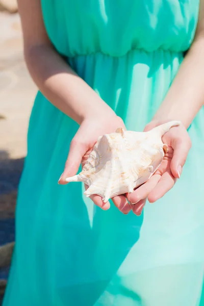 Young girl on summer beach with shell — Stock Photo, Image