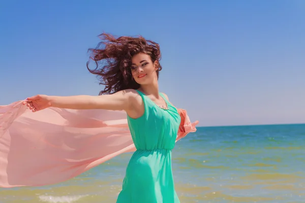 Młoda dziewczyna na plaży latem w piękną sukienkę z latające szalik — Zdjęcie stockowe