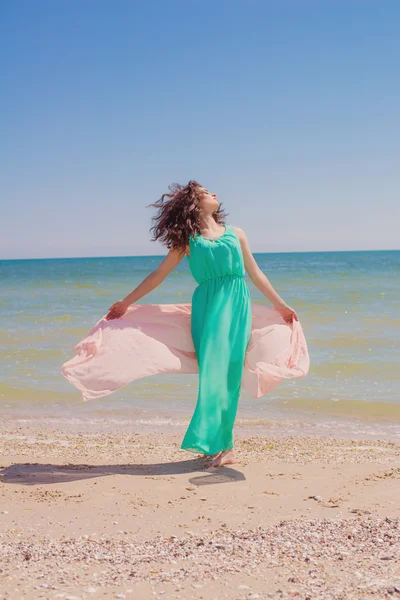 飛行スカーフと美しいドレスの夏のビーチで若い女の子 — ストック写真