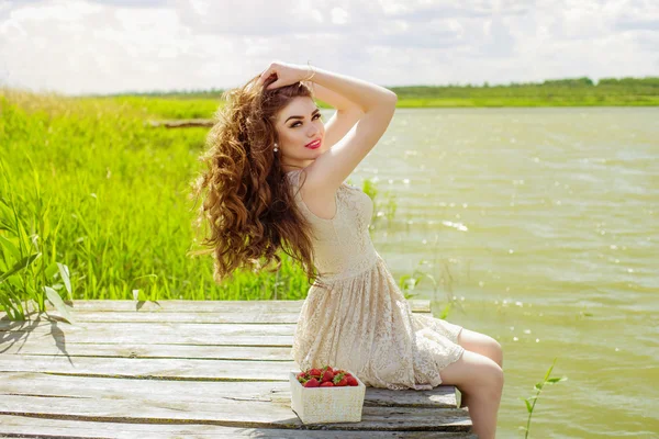 Κορίτσι με μακριά μαλλιά σε νερό το καλοκαίρι με φράουλες — Φωτογραφία Αρχείου