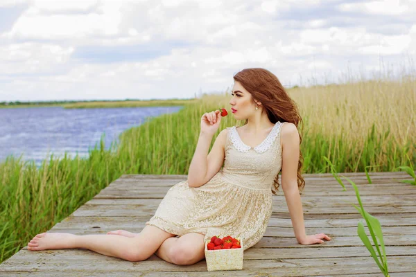 Menina com cabelos longos na água no verão com morangos — Fotografia de Stock