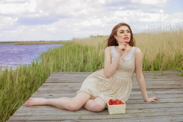 Flicka med långt hår i vatten i sommar med jordgubbar — Stockfoto