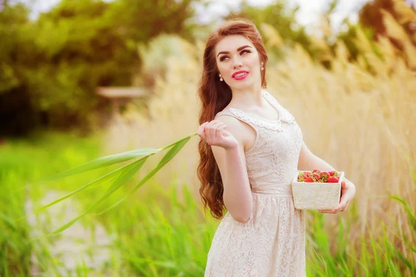 Mädchen mit langen Haaren im Sommer mit Erdbeeren — Stockfoto