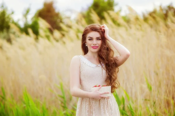 Chica con el pelo largo en verano con fresas — Foto de Stock