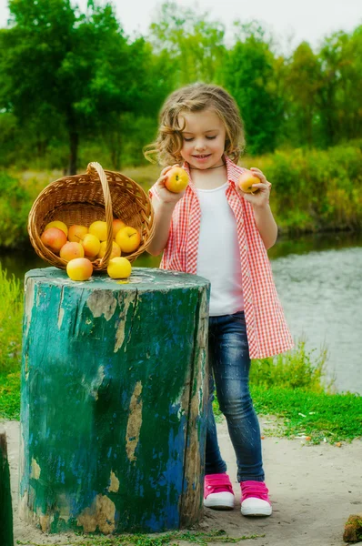 Menina com uma cesta de maçãs — Fotografia de Stock