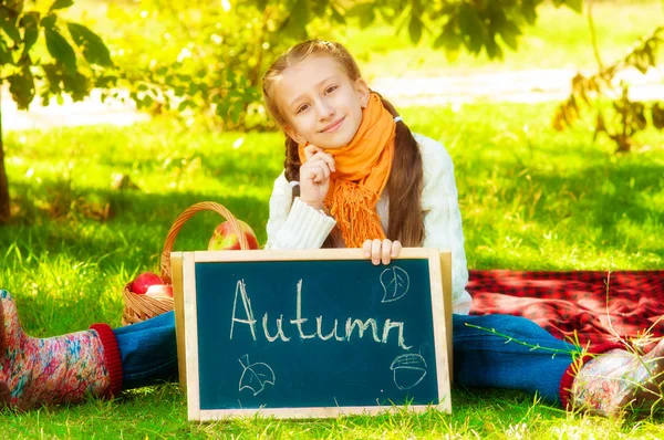 Schoolgirl with apples in autumn — Stock Photo, Image