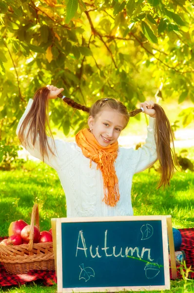 Colegiala con manzanas en otoño — Foto de Stock