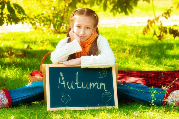 Schoolgirl with apples in autumn — Stock Photo, Image