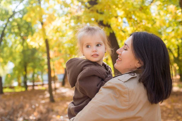 幼い母親と小さな娘が秋の公園を歩いて笑っています 家族だ 秋の気分 — ストック写真
