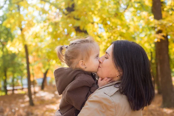 一位年轻的母亲和她的小女儿正在秋天的公园里散步 欢笑着 秋天的心情 — 图库照片