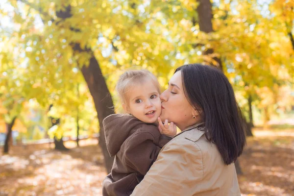 一位年轻的母亲和她的小女儿正在秋天的公园里散步 欢笑着 秋天的心情 — 图库照片