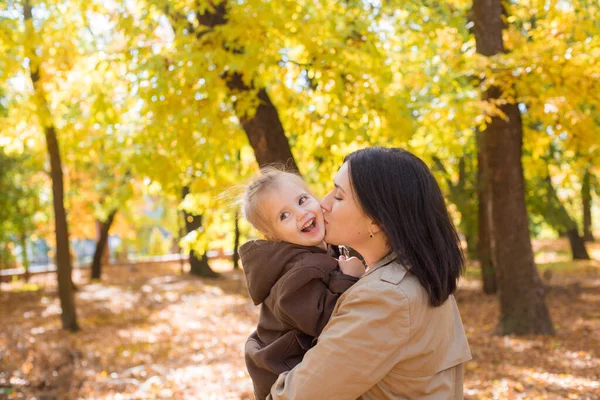 幼い母親と小さな娘が秋の公園を歩いて笑っています 家族だ 秋の気分 — ストック写真