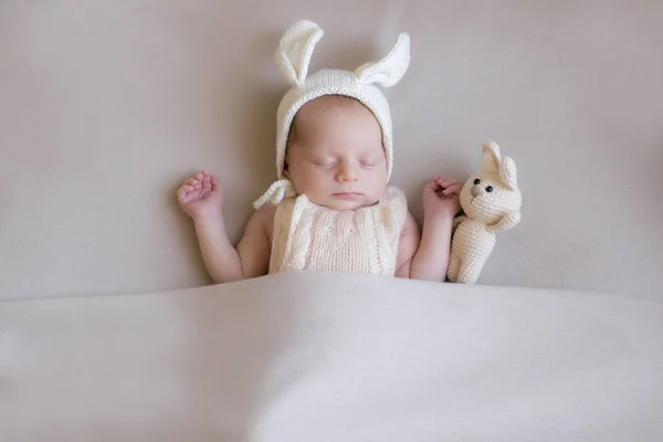 戴着一顶有耳朵的针织兔子帽 头戴米色毛毯的兔子玩具的宝宝 春天的照片复活节和孩子 母性快乐东海岸快乐 — 图库照片