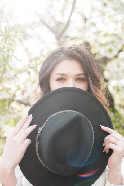 Menina Encantadora Com Chapéu Preto Nas Mãos Primavera Jardim Cereja — Fotografia de Stock