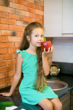 Okul çağındaki tatlı küçük kız mutfakta taze organik sebzelerle. Sağlıklı bebek maması. Sağlıklı yaşam tarzı 
